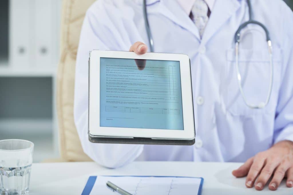 Doctor handing over a patient’s medical record file.