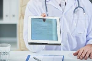 Doctor handing over a patient’s medical record file.