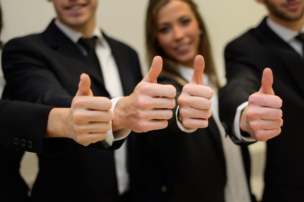 Close-up of multiple hands giving a thumbs up gesture.