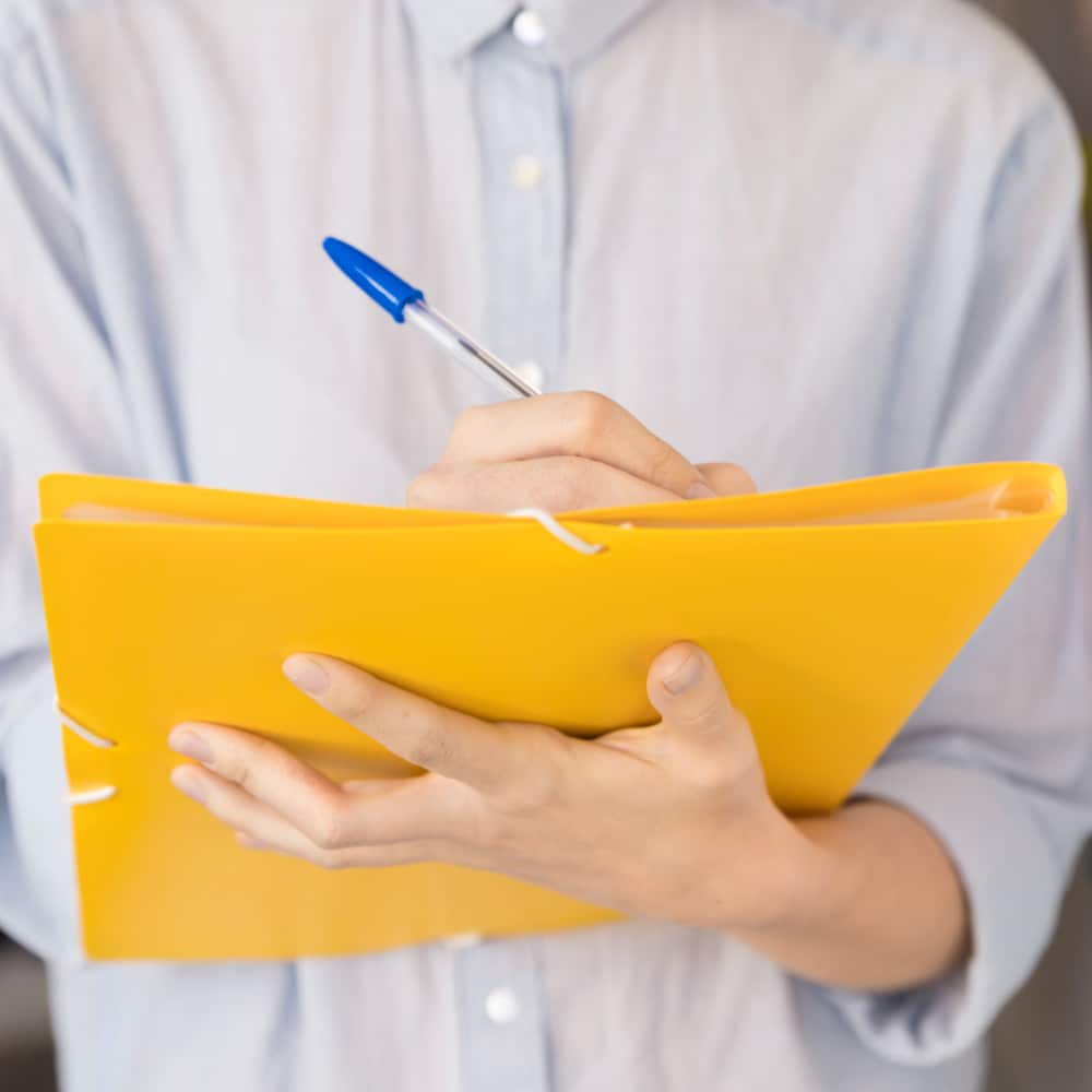 Close-up of female healthcare professional reviewing patient medical records