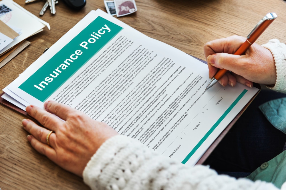 Close-up of hands reviewing insurance policy agreement terms on a document.