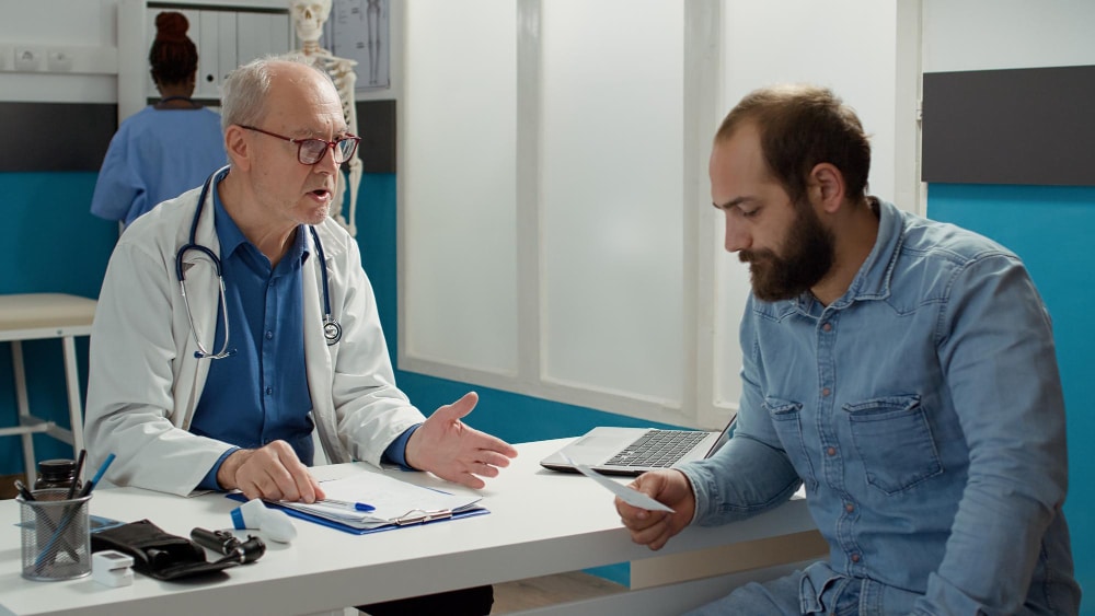 Doctor handing prescription to patient during medical examination