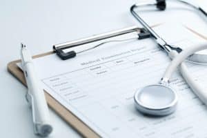 Medical report and stethoscope placed on a clean white desk