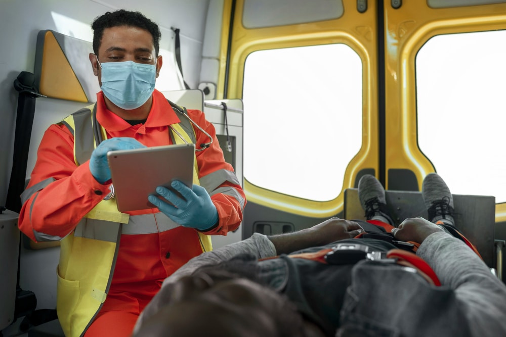 Paramedic in uniform holding tablet computer during emergency response