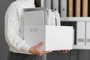 Young adult organizing papers and documents at desk