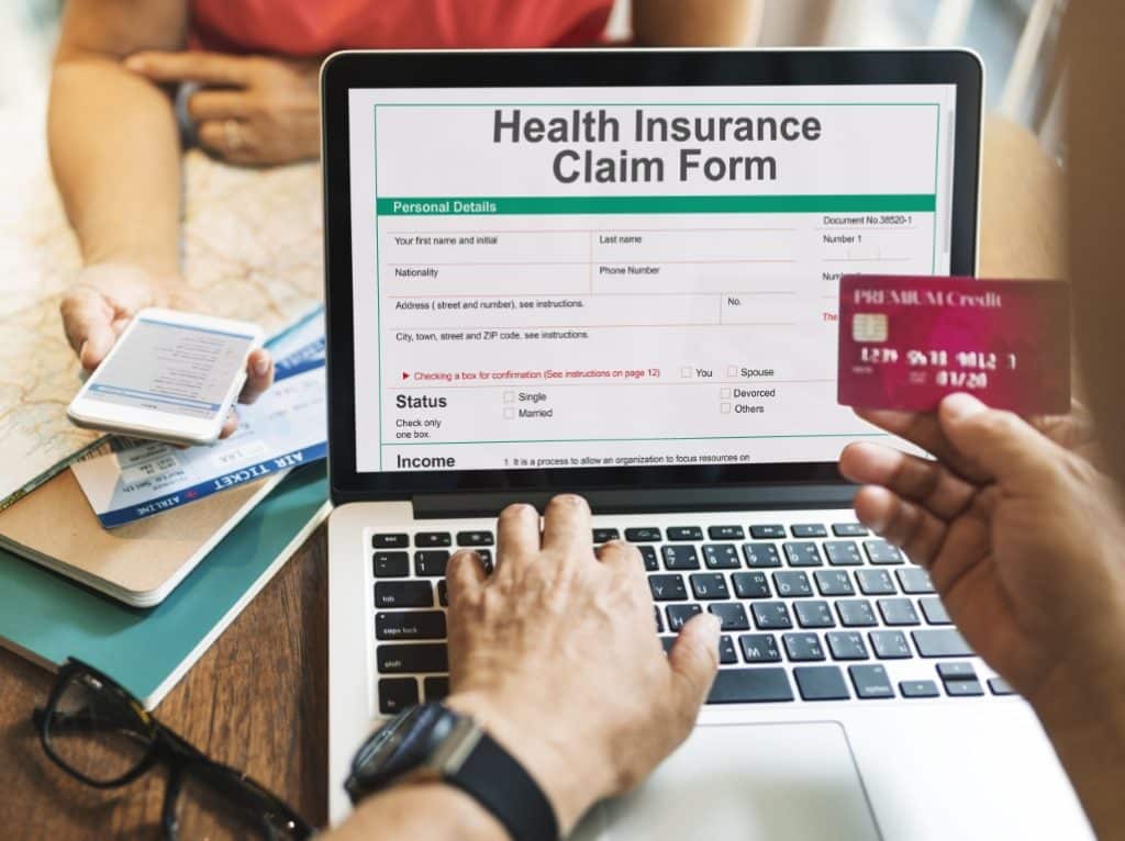 Person using laptop to register for health insurance online.